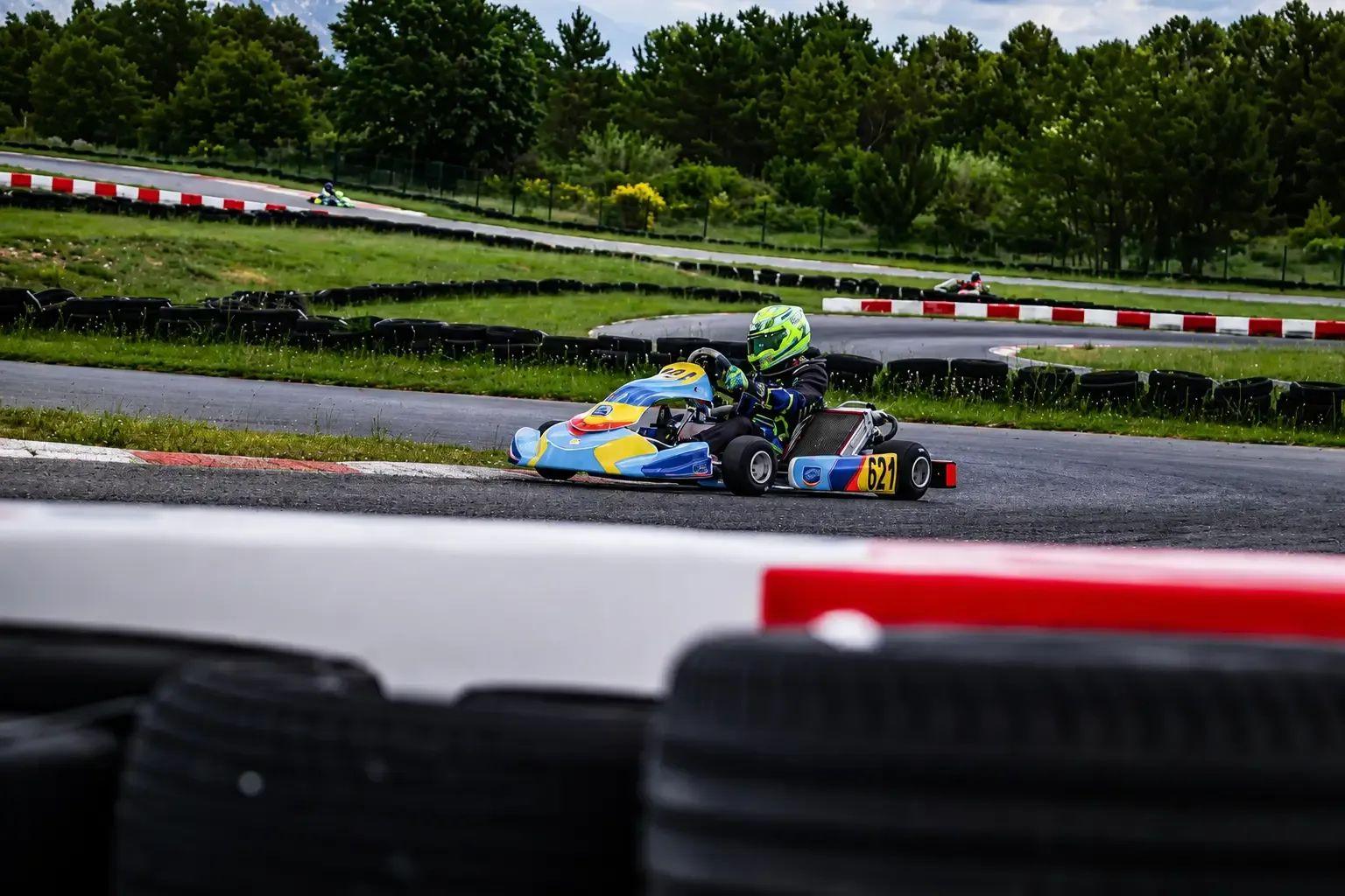 Raphaël en courbe sur un kart bleu et jaune